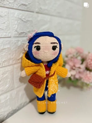 Amigurumi de Coraline con impermeable amarillo